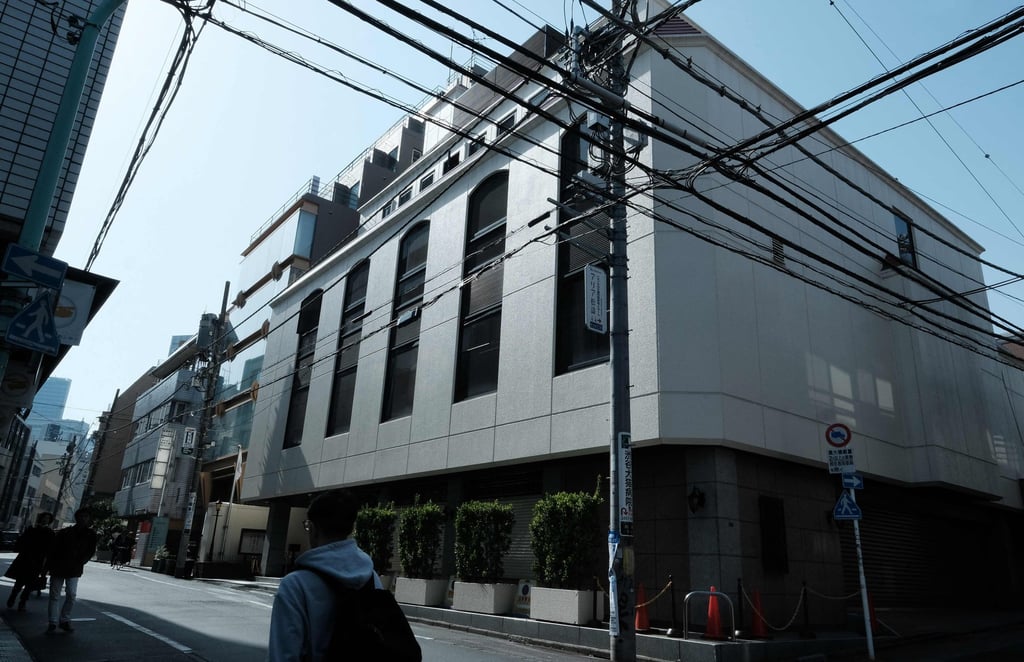 People walk past the Tokyo headquarters of the Unification Church, now called the Family Federation for World Peace and Unification, in the Shibuya ward on March 25. Photo: AFP