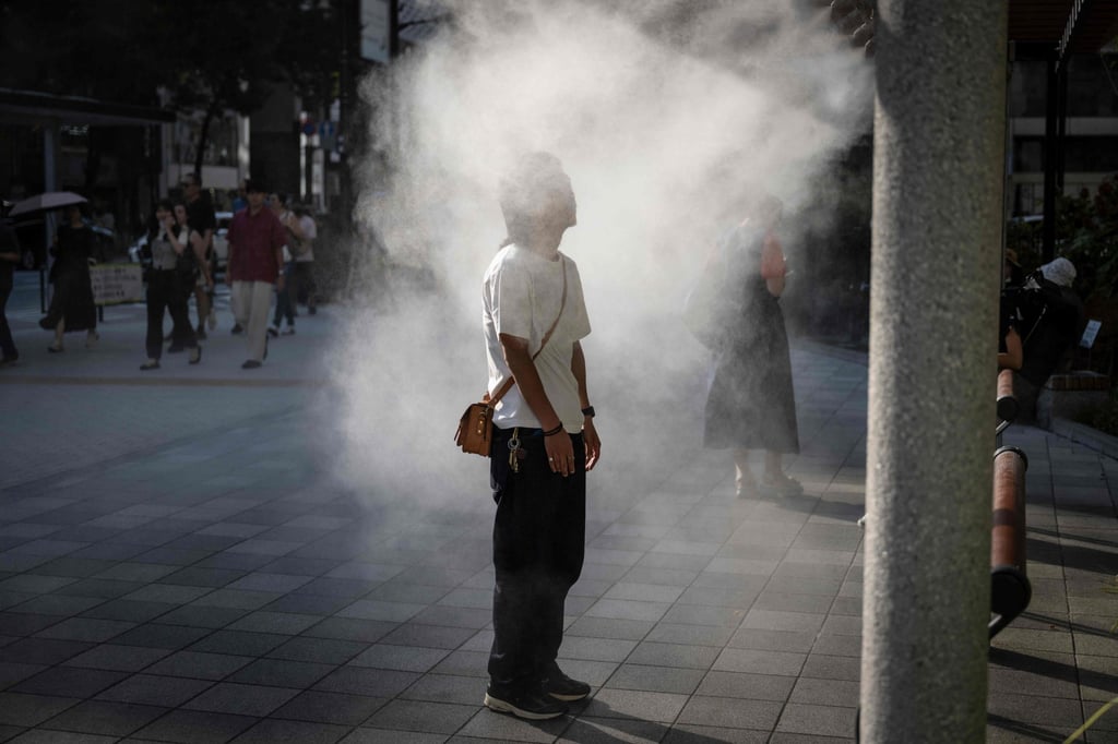 A man rests under a water misting system to cool down on a hot day in Tokyo on September 6. More than 100,000 people in Japan were sent to hospital this summer with heat stroke. Photo: AFP