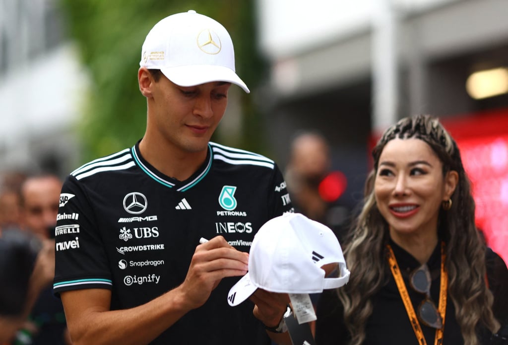 Mercedes driver George Russell signs a hat for a fan ahead of the Singapore Grand Prix. Photo: Reuters