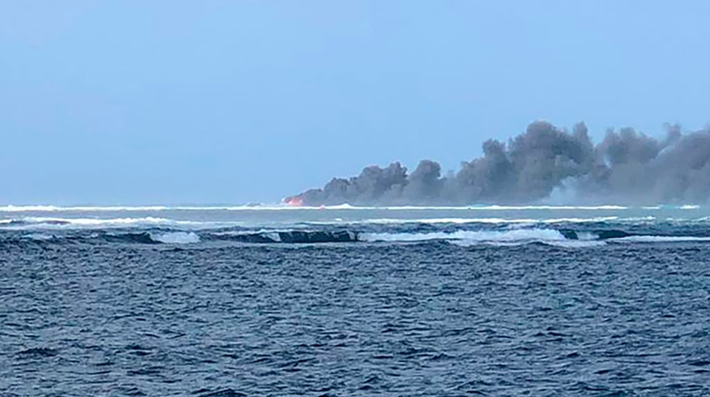 Smoke rises from the sinking HMNZS Manawanui on October 6, last year. Photo: AP