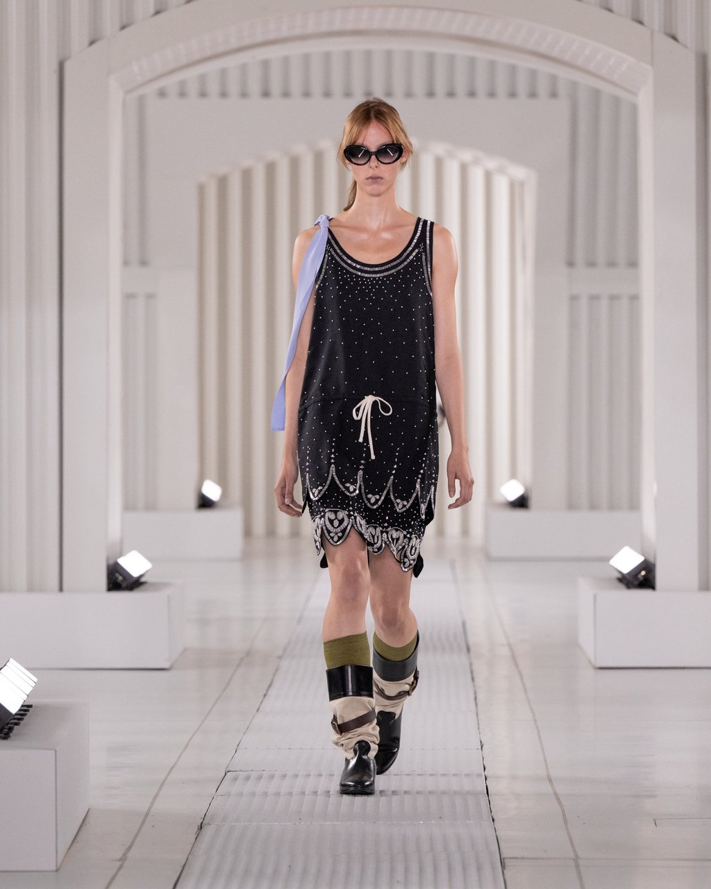 Sleek and edgy: a black studded dress paired with boots and oversized sunglasses, at Onitsuka Tiger spring/summer 2026. Photo: Handout