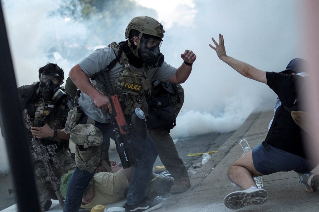 A law enforcement officer confronts a demonstrator during a stand-off with ICE and federal officers in the Little Village neighbourhood of Chicago. Photo: Reuters A law enforcement officer confronts a demonstrator during a stand-off with ICE and federal officers in the Little Village neighbourhood of Chicago. Photo: Reuters
