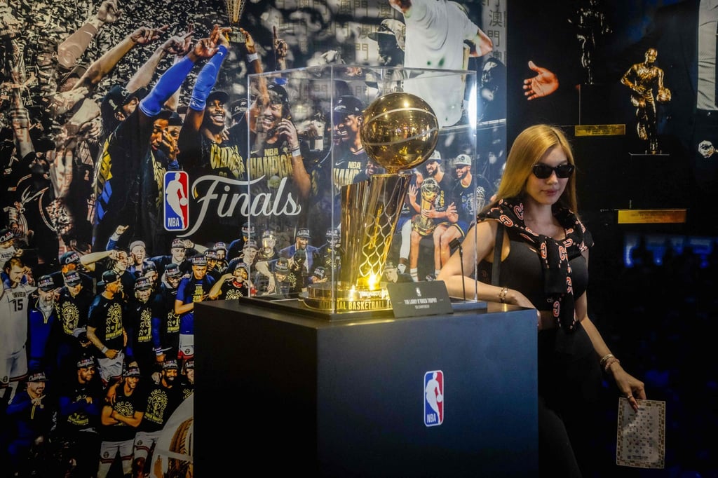 A tourist poses next to the NBA Championship trophy at the NBA House. Photo: AFP A tourist poses next to the NBA Championship trophy at the NBA House. Photo: AFP