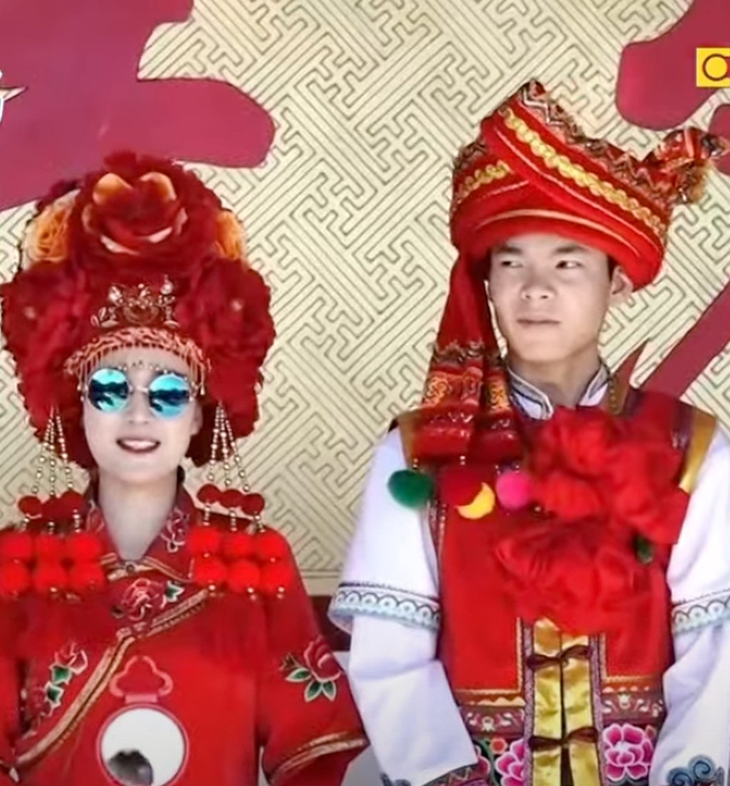 A Bai couple in all their finery, with the bride wearing her obligatory sunglasses. Photo: YouTube