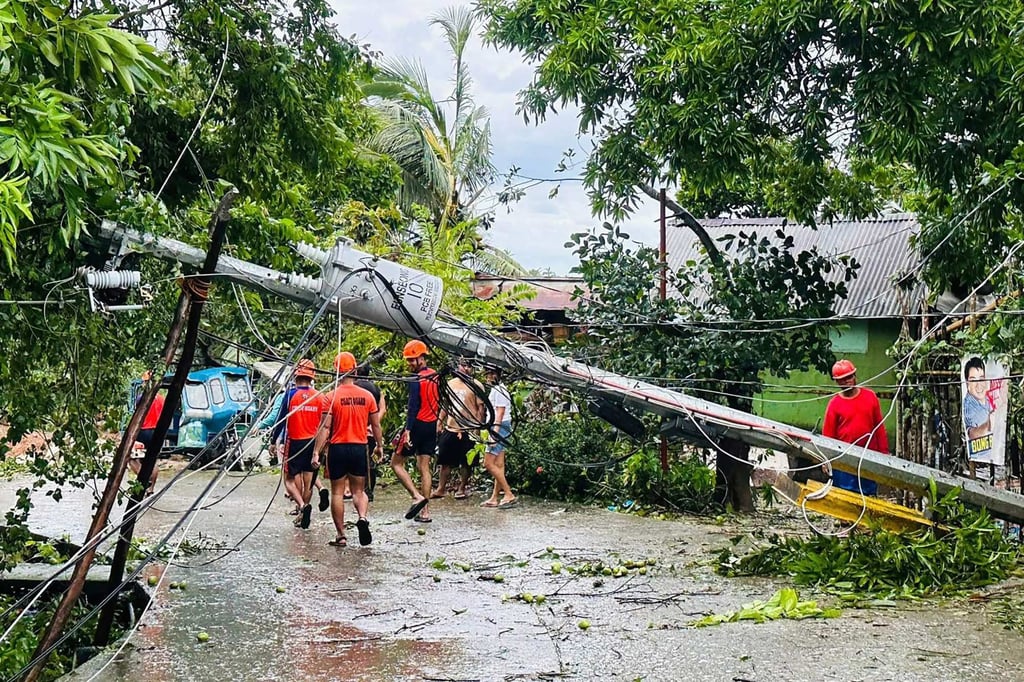 Coast guard personnel walk past a fallen electric post toppled at the height of severe tropical storm Bualoi during clearing operations in Romblon town, central Philippines, on September 27, 2025. Photo: AFP
