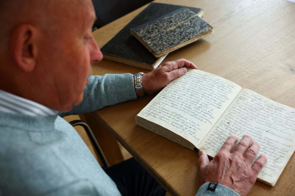 Paul Post, a retired Dutch systems specialist, looks at the wartime diaries of his father in Driehuis, Netherlands, on October 6, 2025. Photo: Reuters