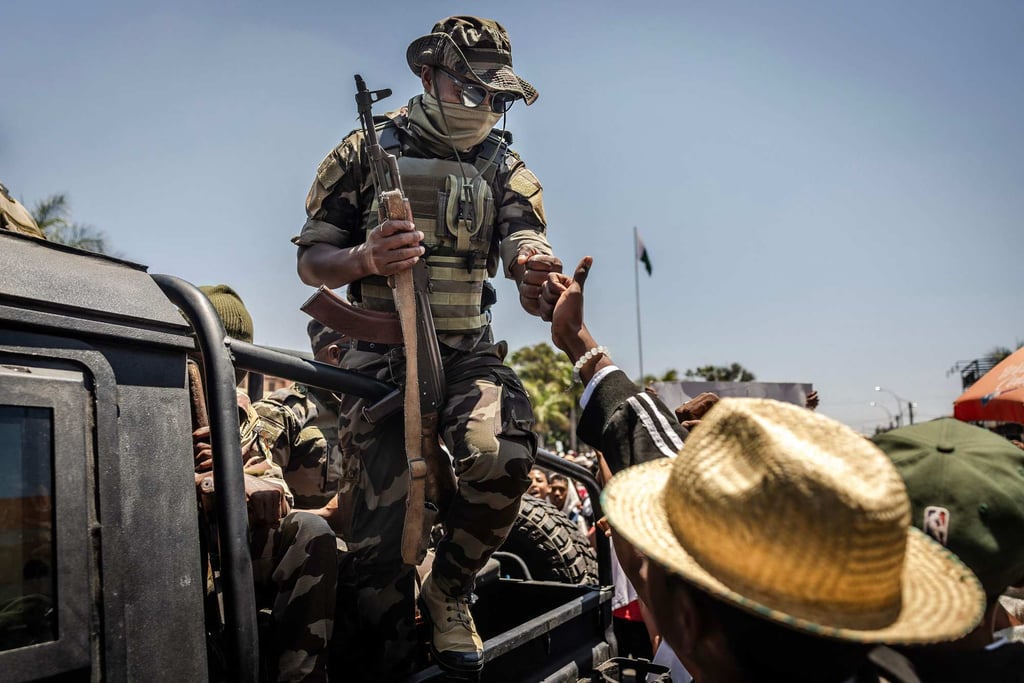 A member of a Malagasy Army unit exchanges a fist bump with a civilian. Photo: AFP A member of a Malagasy Army unit exchanges a fist bump with a civilian. Photo: AFP
