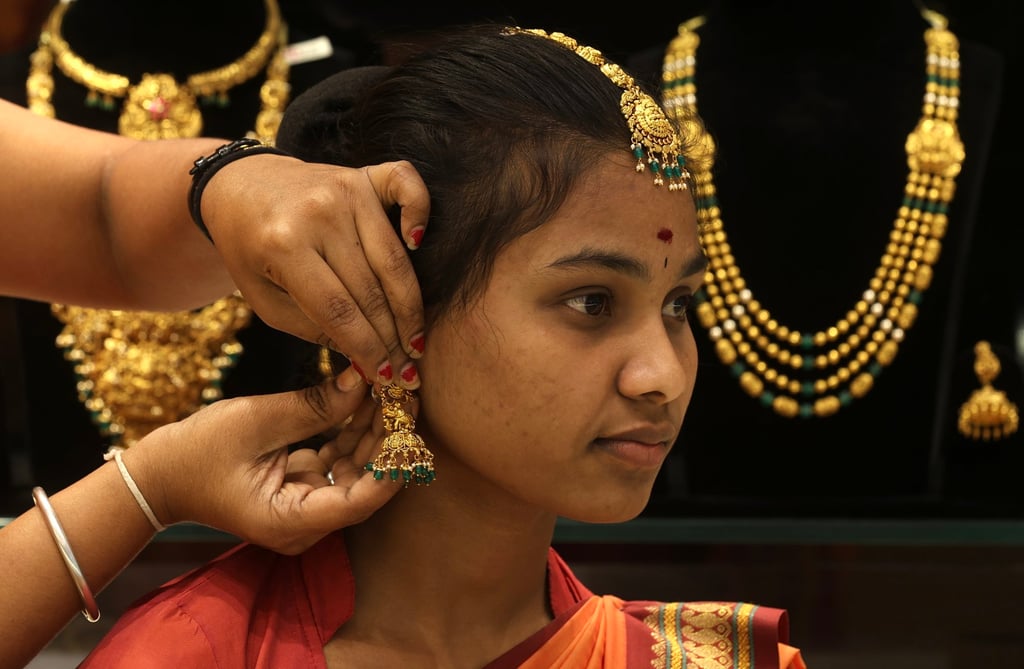 An Indian woman tries on gold ornaments at a jewellery shop in Bengaluru, India, on Monday. Photo: EPA An Indian woman tries on gold ornaments at a jewellery shop in Bengaluru, India, on Monday. Photo: EPA