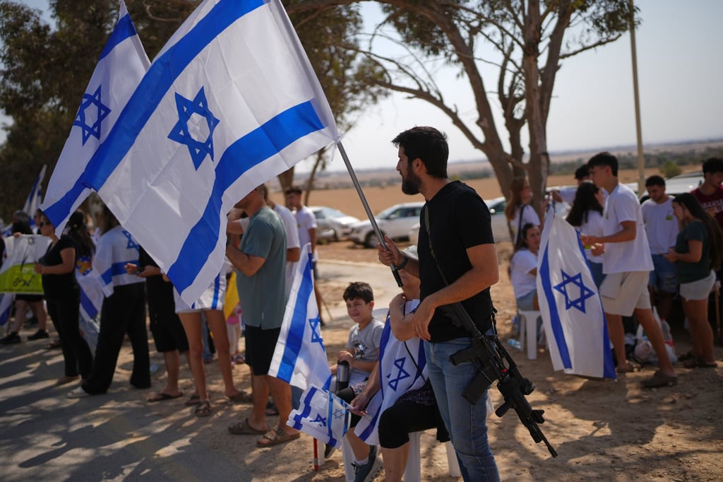 Friends and relatives celebrate before the arrival of the freed Israeli hostage Omri Miran in his home in the Kibbutz Kramim, Israel on Friday. Photo: AP Friends and relatives celebrate before the arrival of the freed Israeli hostage Omri Miran in his home in the Kibbutz Kramim, Israel on Friday. Photo: AP