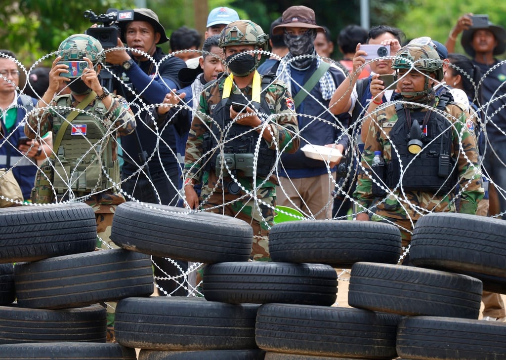 Cambodian troops and villagers stand behind a barbed wire fence opposite Thai officials stationed along the border in Sa Kaeo province, Thailand, last month. Photo: EPA Cambodian troops and villagers stand behind a barbed wire fence opposite Thai officials stationed along the border in Sa Kaeo province, Thailand, last month. Photo: EPA
