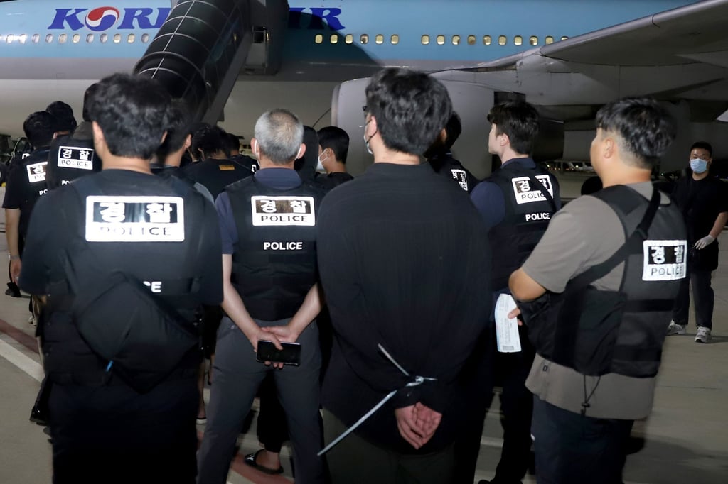 South Korean police escort detainees at Techo International Airport in Phnom Penh, Cambodia, early on Saturday morning. Photo: Agence Kampuchea Presse/EPA South Korean police escort detainees at Techo International Airport in Phnom Penh, Cambodia, early on Saturday morning. Photo: Agence Kampuchea Presse/EPA