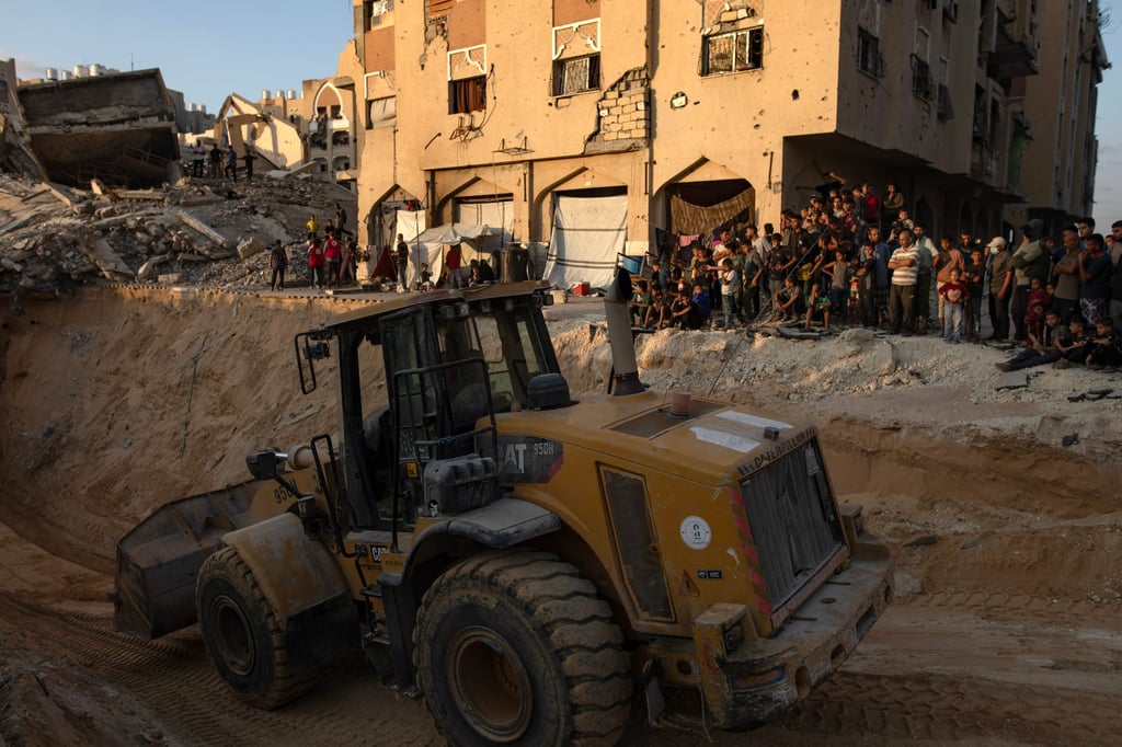 Locals gather to watch as an excavator works at the site where Hamas members are searching for the bodies of Israeli hostages in Khan Younis, in the southern Gaza Strip, on Friday. Photo: EPA Locals gather to watch as an excavator works at the site where Hamas members are searching for the bodies of Israeli hostages in Khan Younis, in the southern Gaza Strip, on Friday. Photo: EPA