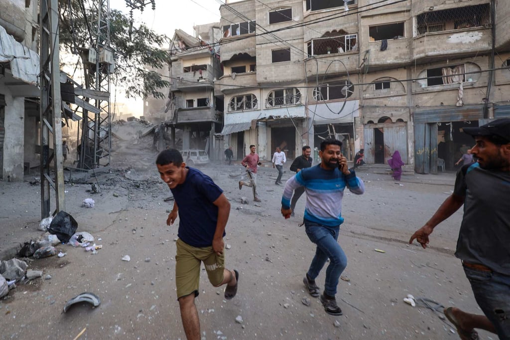 People run for cover following an Israeli strike that targeted a building in the Bureij camp for Palestinian refugees in the central Gaza Strip. Photo: AFP People run for cover following an Israeli strike that targeted a building in the Bureij camp for Palestinian refugees in the central Gaza Strip. Photo: AFP