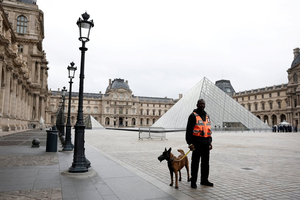 A security employee near the glass Pyramid of the Louvre Museum, which was closed on Monday. Photo: Reuters A security employee near the glass Pyramid of the Louvre Museum, which was closed on Monday. Photo: Reuters