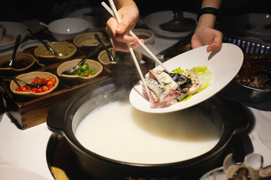 Fresh fish belly is added to the congee hotpot base at Da Liang Wu Mi Zhou. Photo: Hei-kiu Au De la poitrine de poisson fraîche est ajoutée à la base de fondue de congee à Da Liang Wu Mi Zhou. Photo : Hei-kiu Au