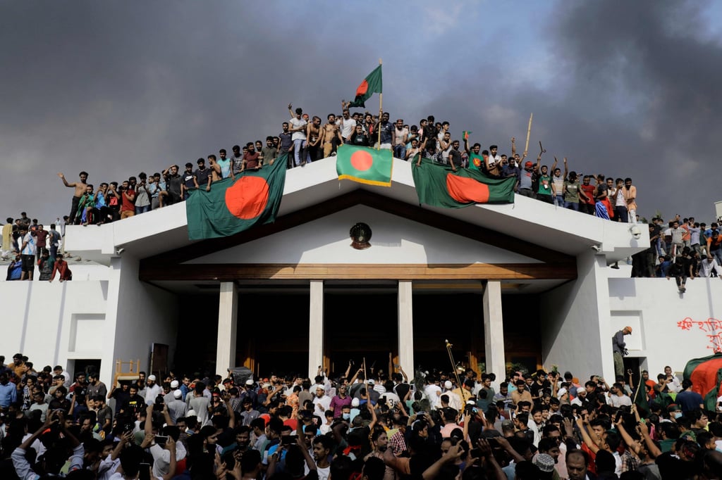 Anti-government protesters display Bangladesh’s national flag as they storm then prime minister Sheikh Hasina’s palace in Dhaka on August 5, 2024. Hasina later fled to India. Photo: AFP Anti-government protesters display Bangladesh’s national flag as they storm then prime minister Sheikh Hasina’s palace in Dhaka on August 5, 2024. Hasina later fled to India. Photo: AFP