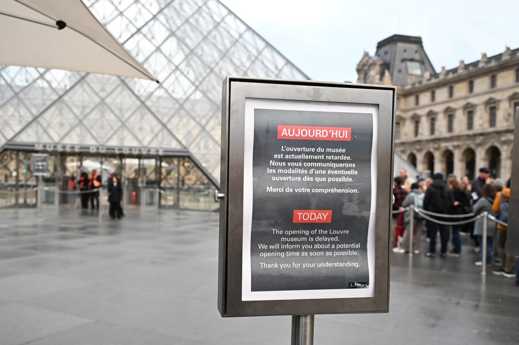 A board reads that the opening of the Louvre museum is delayed, but it remained closed for the day after Sunday’s jewels robbery. Photo: AP Photo
