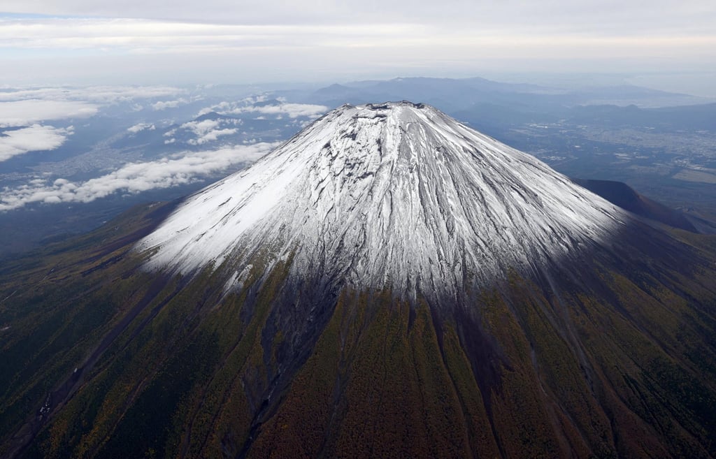 The season’s first snowcap on Mount Fuji, Japan’s highest mountain, located on the borders of Shizuoka and Yamanashi prefectures, on Thursday. Photo: Kyodo via Reuters