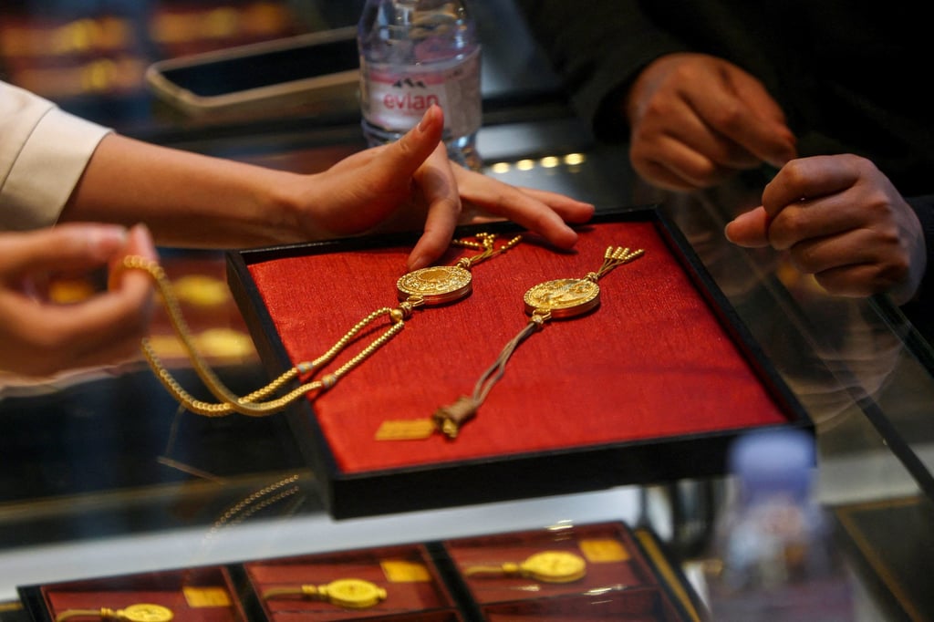A staff member attends to a customer at a Laopu Gold store in Beijing. Photo: Reuters A staff member attends to a customer at a Laopu Gold store in Beijing. Photo: Reuters