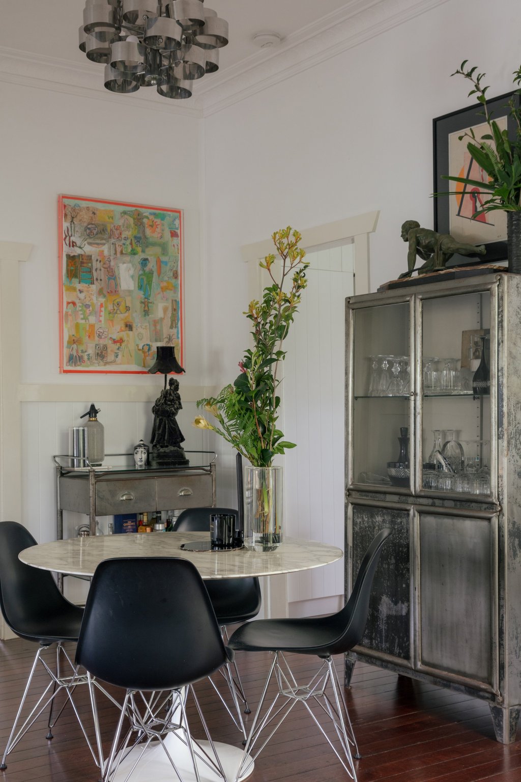 Ross Urwin’s 20th century furniture collection includes an Eero Saarinen Tulip table, Eames Moulded Plastic chairs, a repurposed British hospital trolley and a Curtis Jeré chrome chandelier, bought at the Fiera di Parma antiques fair in Italy. Above the trolley is a painting by Toze Figueiredo. Photo: Aaron Chapman Ross Urwin’s 20th century furniture collection includes an Eero Saarinen Tulip table, Eames Moulded Plastic chairs, a repurposed British hospital trolley and a Curtis Jeré chrome chandelier, bought at the Fiera di Parma antiques fair in Italy. Above the trolley is a painting by Toze Figueiredo. Photo: Aaron Chapman