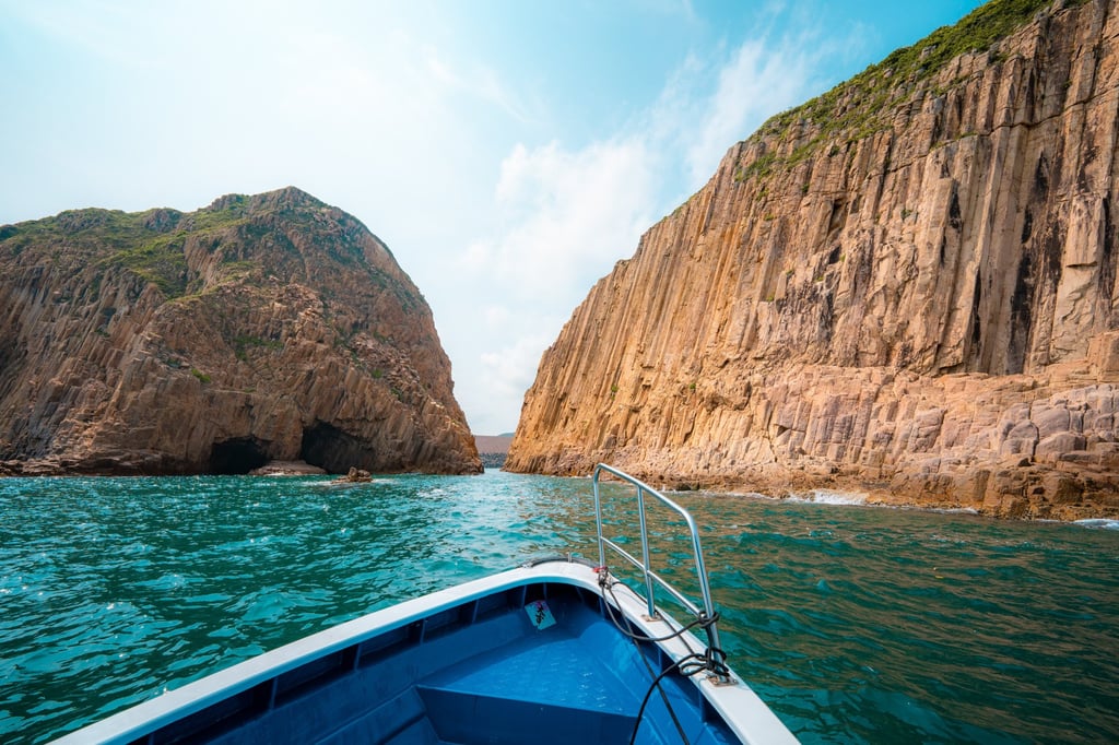 A boat tour is the ideal way to appreciate the dramatic hexagonal volcanic columns in the craggy cliffs of Sai Kung Volcanic Rock Region in Hong Kong Unesco Global Geopark.