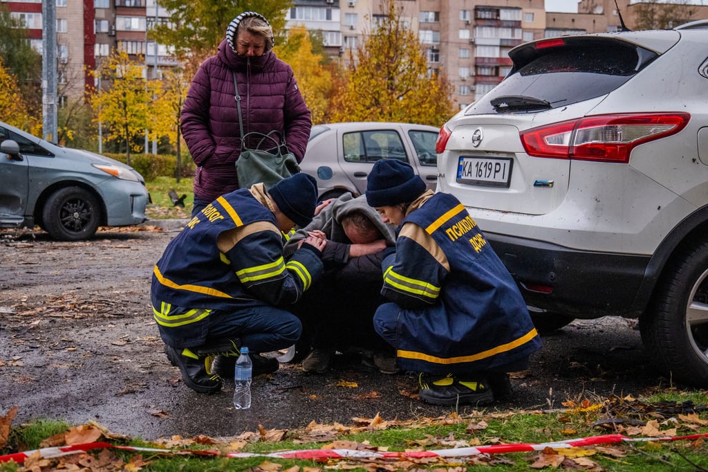 Emergency workers comfort a man who lost his son in a drone attack. Photo: AP Emergency workers comfort a man who lost his son in a drone attack. Photo: AP