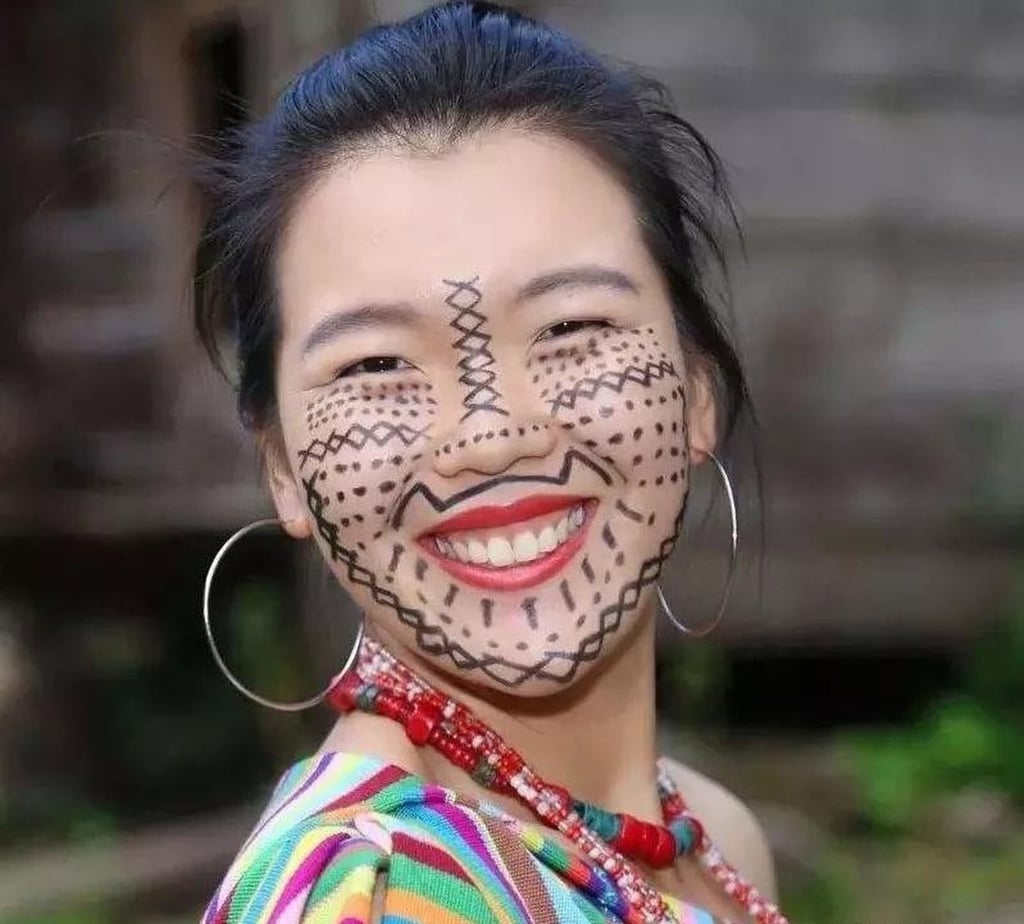 A happy Dulong woman shows off her tattoo which is said to prevent abduction. Photo: Sohu/Zhihu