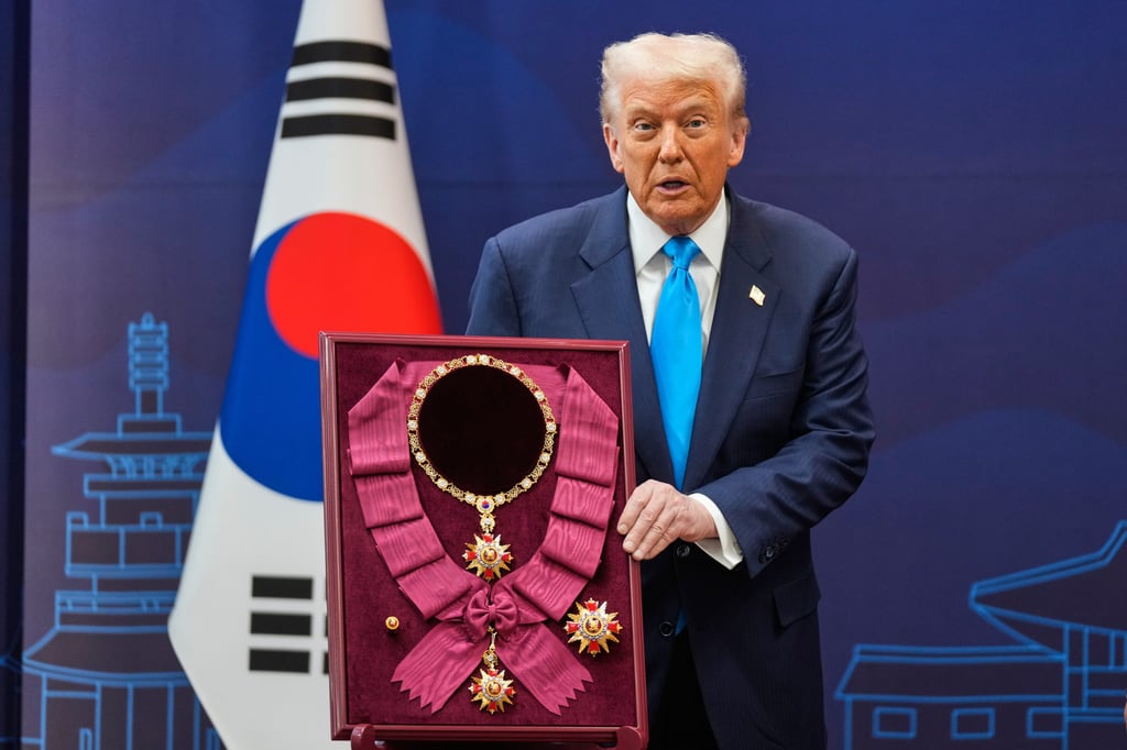 Trump poses with the “Grand Order of Mugunghwa” award. Photo: AP