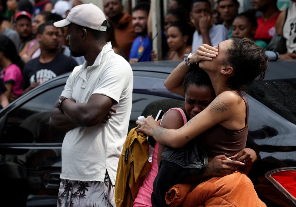 Mourners gather around bodies. Photo: Reuters