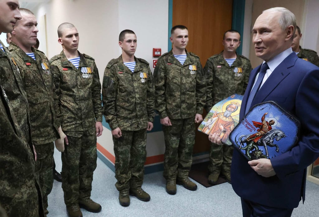 Russia’s President Vladimir Putin visits soldiers who were wounded in Ukraine, at a military hospital in Moscow. Photo: Sputnik and AFP