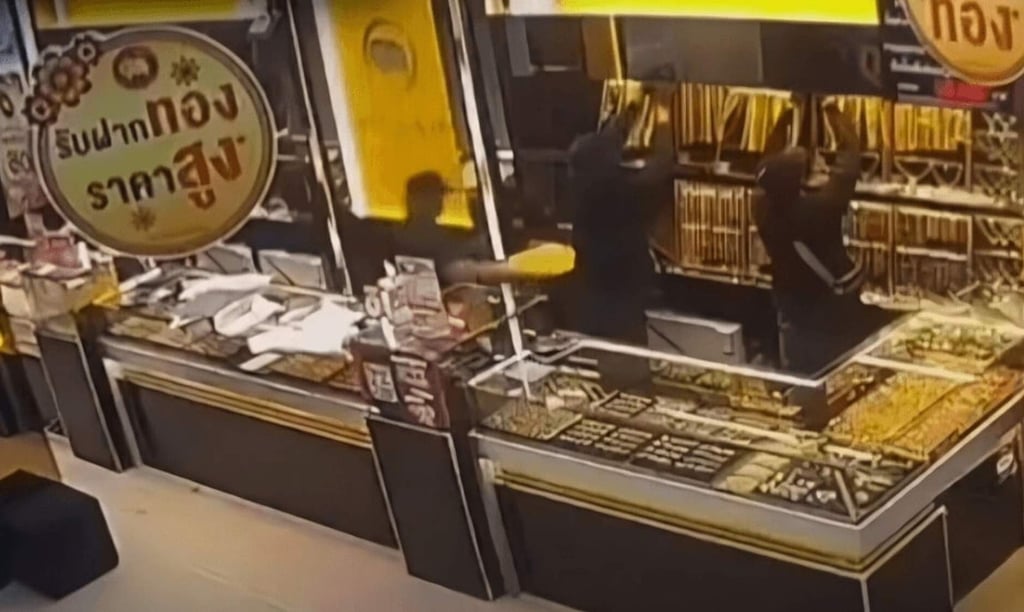 A still from CCTV footage shows the suspects grabbing gold chains from the shop. Photo: Thai police A still from CCTV footage shows the suspects grabbing gold chains from the shop. Photo: Thai police