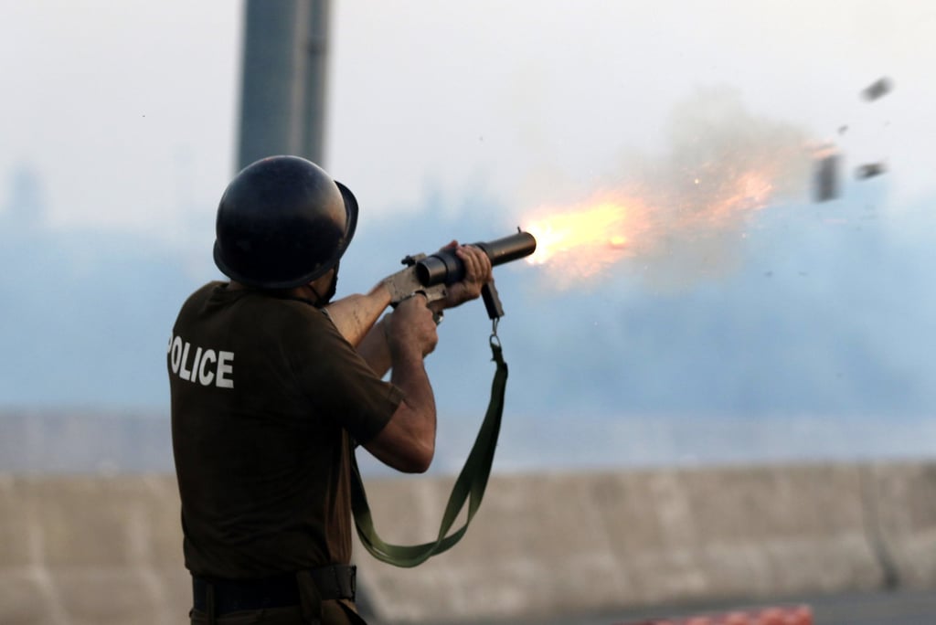 A Pakistani policeman fires tear gas shells to disperse TLP supporters on October 10. Photo: EPA A Pakistani policeman fires tear gas shells to disperse TLP supporters on October 10. Photo: EPA