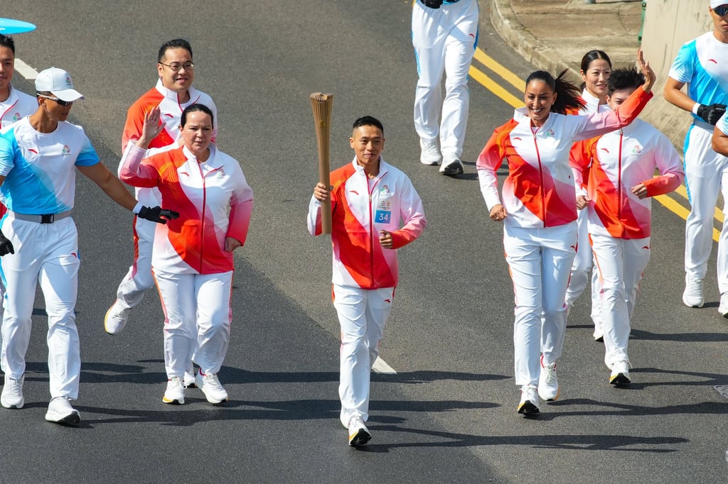 Renowned horse racing jockey Vincent Ho Chak-yiu carries the torch on Salisbury Road during the 15th National Games torch relay in Hong Kong, on November 2. Photo: Sun Yeung Renowned horse racing jockey Vincent Ho Chak-yiu carries the torch on Salisbury Road during the 15th National Games torch relay in Hong Kong, on November 2. Photo: Sun Yeung