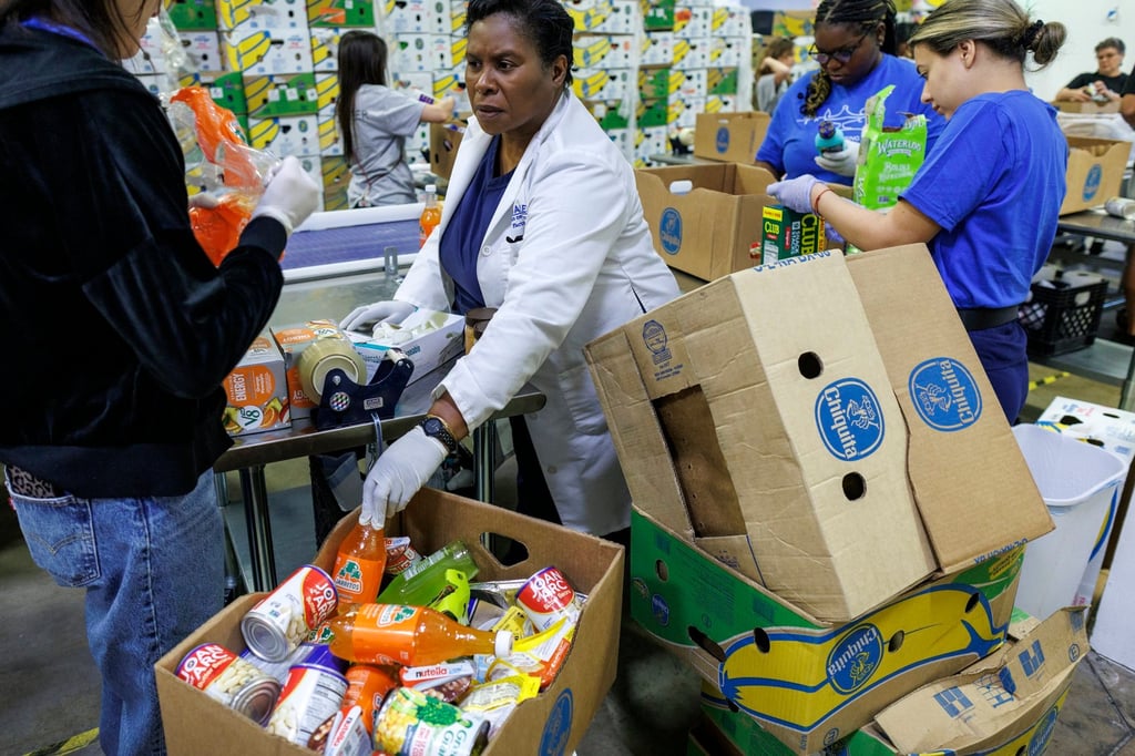 Volunteers stock items at the Feeding South Florida food bank facility in Pembroke Park, Florida, on Tuesday. Photo: EPA Volunteers stock items at the Feeding South Florida food bank facility in Pembroke Park, Florida, on Tuesday. Photo: EPA