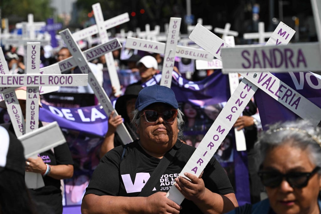 Members of the feminist collective “Voces de la Ausencia” carry crosses during a march in Mexico on Monday in memory of women killed in gender-based violence and femicides. Photo: AFP