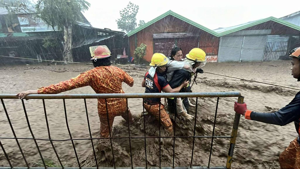 Firefighters rescue a woman in Canlaon City, Negros Oriental province, on Wednesday. Photo: BFP-Canlaon/AFP Firefighters rescue a woman in Canlaon City, Negros Oriental province, on Wednesday. Photo: BFP-Canlaon/AFP