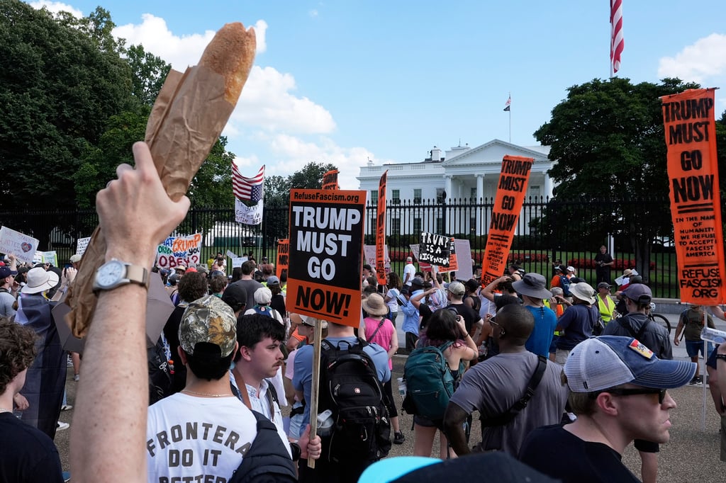 A protester in Washington in August holds up a baguette in support of a fired former Justice Department employee who hurled a sandwich at a federal law enforcement official. Photo: AP A protester in Washington in August holds up a baguette in support of a fired former Justice Department employee who hurled a sandwich at a federal law enforcement official. Photo: AP