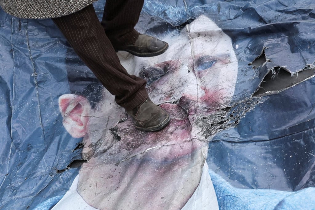 A man in Damascus walks on a poster of Bashar al-Assad after the Syrian dictator’s ousting in December 2024. Photo: Reuters