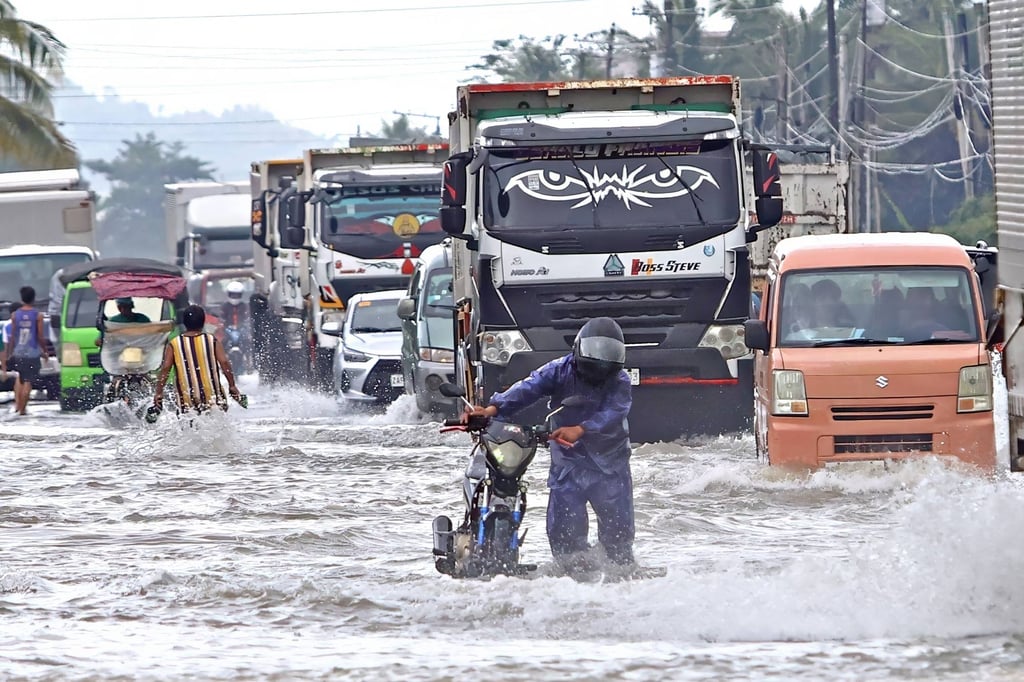 A motorist wades through a flooded highway in Remedios T. Romualdez, Mindanao island, on Saturday. Photo: AFP A motorist wades through a flooded highway in Remedios T. Romualdez, Mindanao island, on Saturday. Photo: AFP