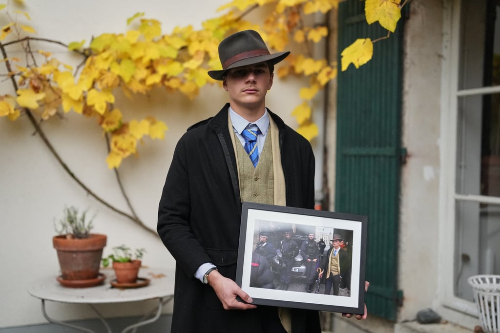 Pedro Elias Garzon Delvaux poses with an Associated Press photo of him outside the Louvre on the day of the crown jewels heist. Photo: AP
