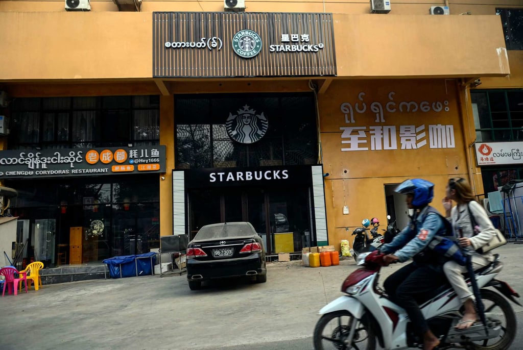 People ride their motorbike past a restaurant and a cafe in Shwe Kokko in Myanmar’s eastern Myawaddy township earlier this year. Photo: AFP