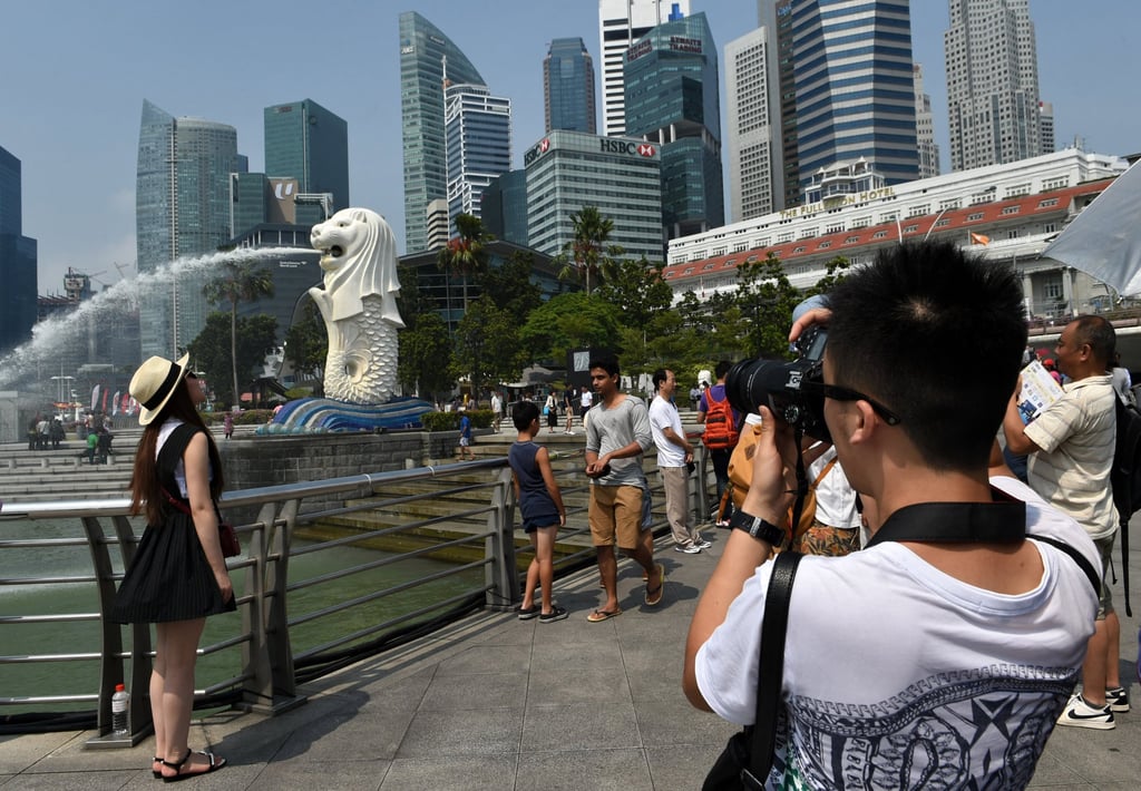 Chinese tourists take pictures near the Merlion statue in Singapore. Photo: AFP