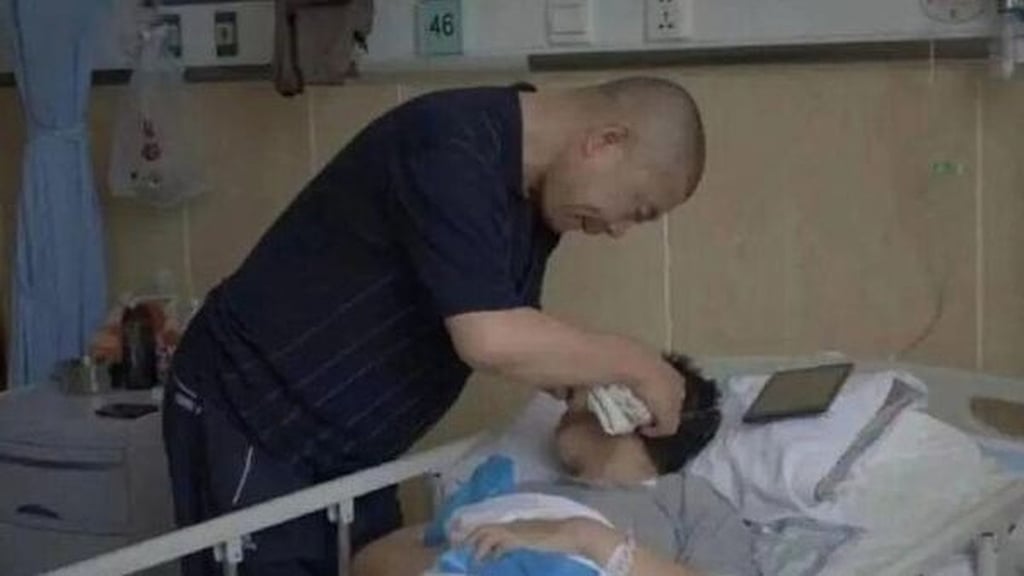 Gui Junmin tends to his wife in her hospital bed before she underwent the freezing procedure. Photo: infzm.com Gui Junmin tends to his wife in her hospital bed before she underwent the freezing procedure. Photo: infzm.com