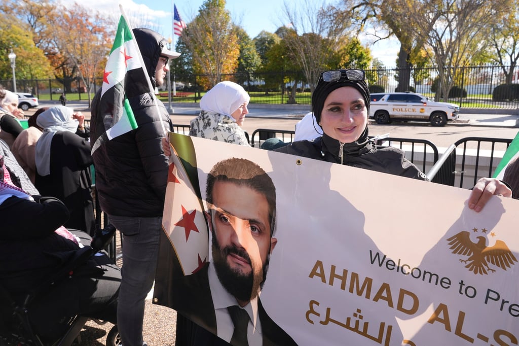 Motiah Boustany of Charlestown, West Virginia, holds a banner depicting Sharaa outside the White House in Washington on Monday. Photo: AP Motiah Boustany of Charlestown, West Virginia, holds a banner depicting Sharaa outside the White House in Washington on Monday. Photo: AP