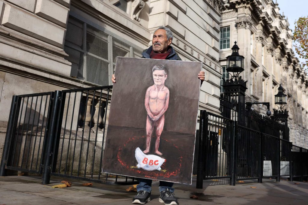 Political satire artist Kaya Mar holds a painting of Keir Starmer with a headless chicken with the words BBC outside Downing Street on Wednesday. The BBC’s outgoing boss urged staff to “fight” for journalism amid Trump’s threat to sue over a misleading edit. Photo: Adrian Dennis/AFP