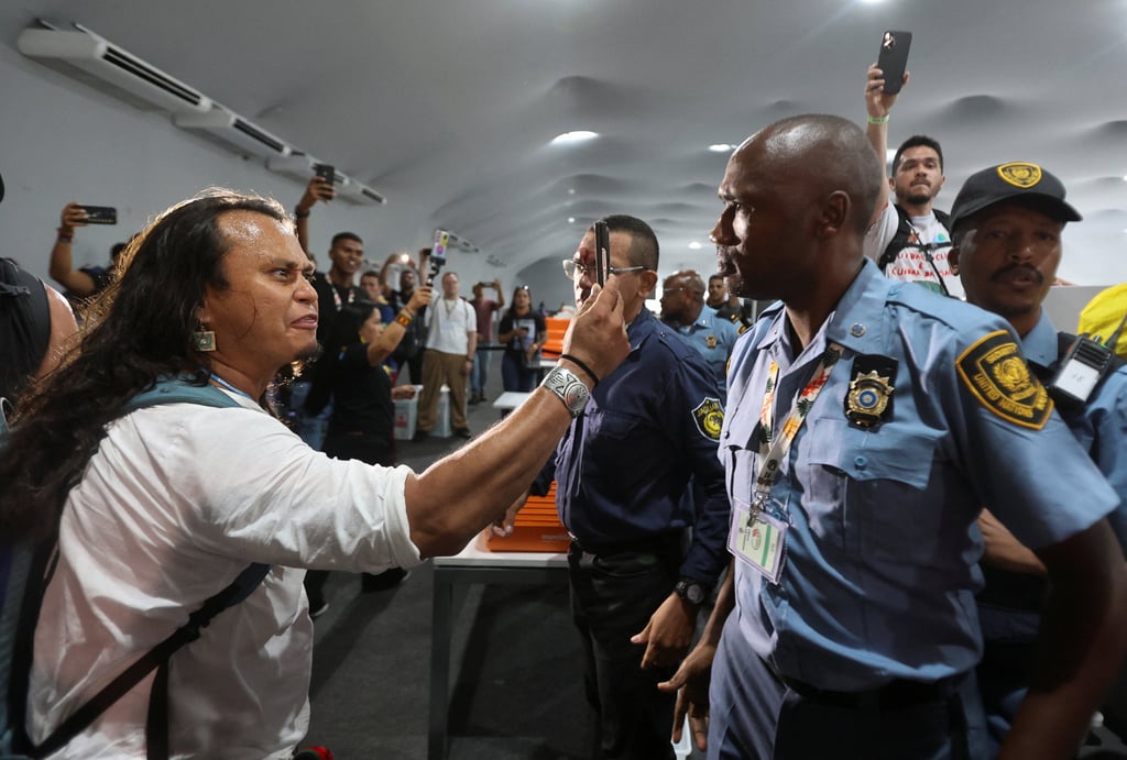 A protester holds a mobile phone while standing in front of security staff. Photo: Reuters A protester holds a mobile phone while standing in front of security staff. Photo: Reuters