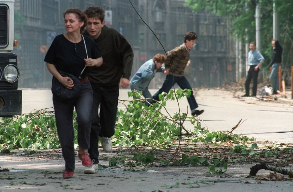Sarajevo residents run through an intersection known for sniper activity in 1992. Photo: AFP