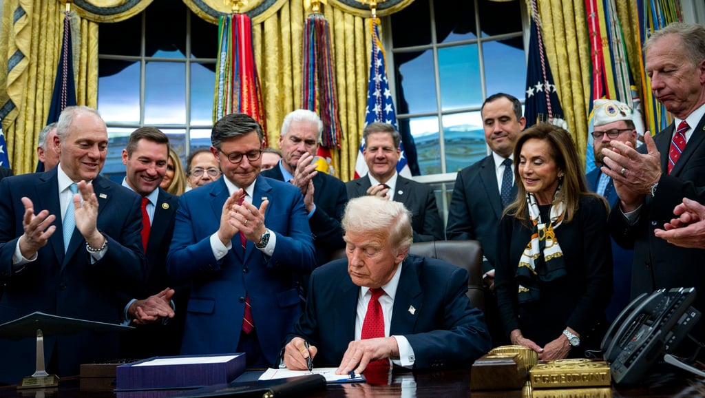 US President Donald Trump (centre) signs the funding package to re-open the federal government in the Oval Office on Wednesday, ending the longest shutdown in US history. Photo: EPA