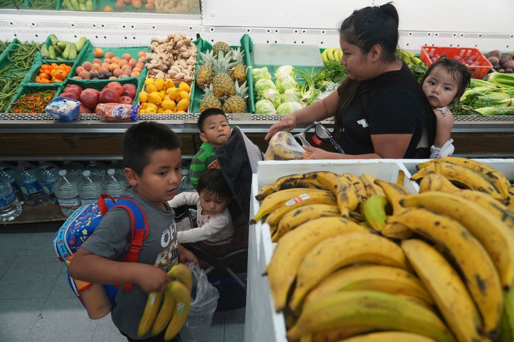 A woman buys fruit for her children in Los Angeles in October. Photo: AP A woman buys fruit for her children in Los Angeles in October. Photo: AP