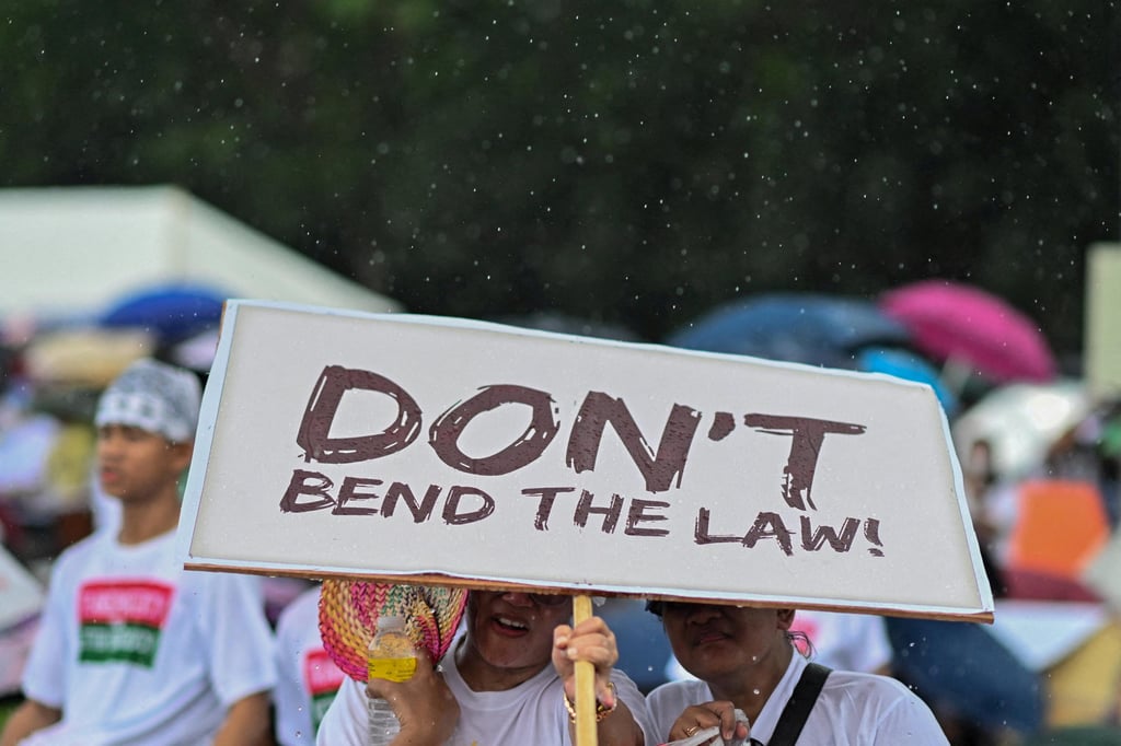 A member of the religious group Iglesia ni Cristo holds a sign during an anti-corruption protest at the Quirino Grandstand, Manila, the Philippines, on Sunday. Photo: Reuters A member of the religious group Iglesia ni Cristo holds a sign during an anti-corruption protest at the Quirino Grandstand, Manila, the Philippines, on Sunday. Photo: Reuters